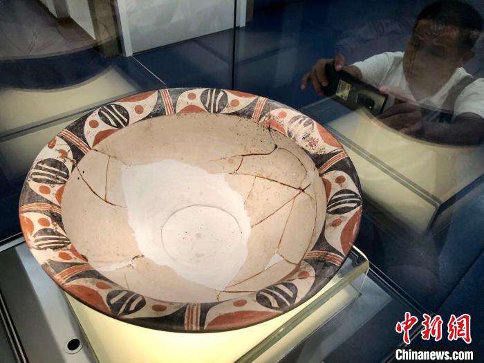 观众拍摄展示的精美彩陶盆
