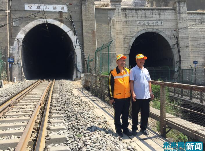 王永民与王钧父子二人在新旧宝塔山隧道前合影.(未来网记者 何欣摄)